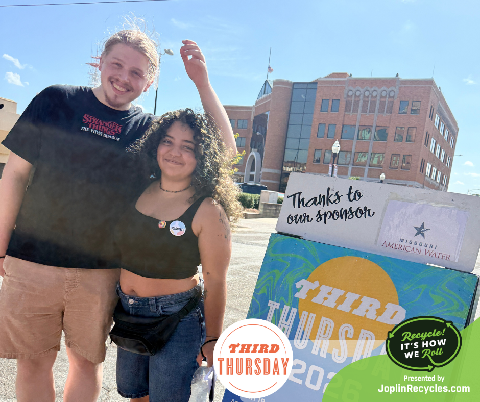 Two young volunteers stand at a street closure for 2026 Third Thursday event